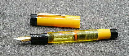 Orville - Medium - Solid Yellow and black, clear yellow acrylics - clip - piston - #6 nib