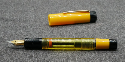 Orville - Medium - Solid Yellow and black, clear yellow acrylics - clip - piston - #6 nib